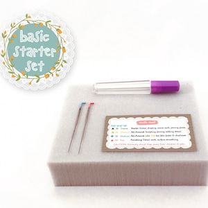 May include: A basic starter set for polymer clay sculpting includes three needles of different sizes, a needle tool holder, and a card with needle gauge information and instructions. The needles are brown with colored tips and the holder is clear with a purple top.