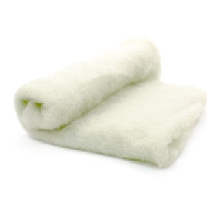 May include: A rolled-up, off-white felt fabric, partially unrolled, against a white background. The felt has a soft, textured appearance. The fabric is likely used for crafts or other textile projects.