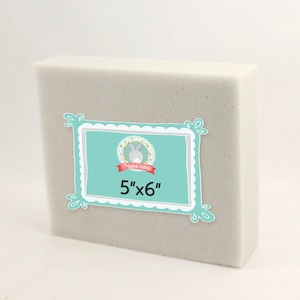 May include: A white rectangular foam block measuring 5 inches by 6 inches. The block is used for crafting and floral arrangements.