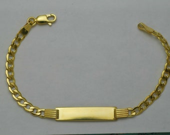 May include: A gold chain bracelet with a rectangular nameplate charm. The chain is a curb style and the clasp is a lobster claw.