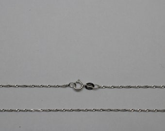 May include: A silver chain necklace with a twisted rope design. The chain is approximately 18 inches long and has a lobster clasp.