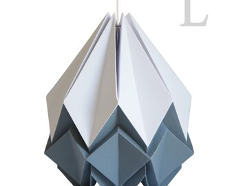 Puede incluir: Una lámpara colgante de origami gris y blanco. La luz tiene forma de flor geométrica con una parte superior puntiaguda y una parte inferior redondeada. La luz cuelga de un cable blanco.