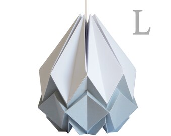 Puede incluir: Una lámpara colgante de papel origami blanco y gris. La luz tiene forma de estrella geométrica con una parte superior puntiaguda y una parte inferior redondeada. La luz está etiquetada con la letra "L".
