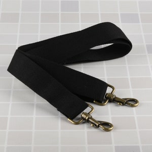 Puede incluir: Correa de lona negra con dos cierres de metal dorado antiguo.