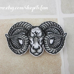 May include: Embroidered patch featuring a ram's head with large, curved horns. The design is in black and gray thread on a white background. The patch has a white border. Text at the top reads "www.etsy.com/shop/lxfun".