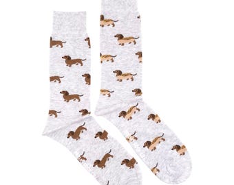 May include: A pair of gray socks with a pattern of brown dachshunds. The socks are shown laid flat on a white background.