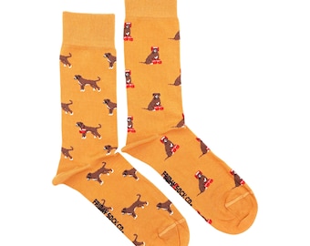 May include: Mustard yellow socks with a repeating pattern of brown dogs. Some dogs are wearing red hats and riding skateboards. The text "FRIDAY SOCK CO." is printed on the foot of each sock.