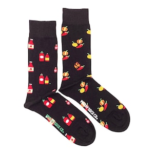 May include: A pair of black socks with a fun pattern of red hot sauce bottles, yellow peppers, and red chilli peppers. The socks have the text "Friday Sock Co." on the bottom.