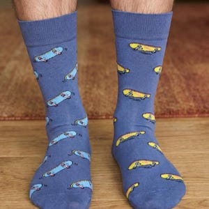 May include: A pair of blue socks with a pattern of skateboards in yellow and blue. The socks are made of a soft material and are designed to fit comfortably. The socks are a fun and stylish accessory.
