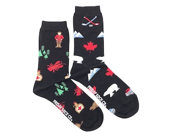May include: A pair of black socks with colorful Canadian themed designs. One sock features a maple leaf, mountains, a polar bear, and hockey sticks. The other sock features a lumberjack, a lobster, a maple syrup bottle, and a beaver. Both socks have the text "FRIDAY SOCK CO." printed on the bottom.