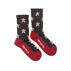 Könnte beinhalten: Ein Paar dunkelgraue Socken mit roter Ferse und Zehen. Die Socken haben ein Muster aus Lebkuchenmännern. Der Text "FRIDAY SOCK CO." ist auf dem roten Teil der Socken aufgedruckt.