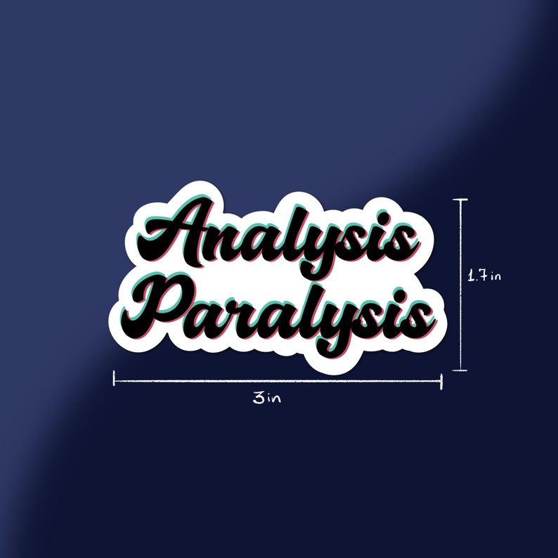 May include: A white sticker with the words "Analysis Paralysis" in black, outlined in red and teal, against a dark blue background. The sticker measures 3 inches wide and 1.7 inches tall.