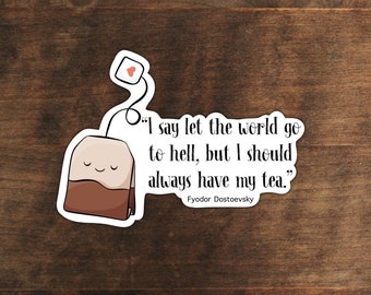 Op de afbeelding: Een witte sticker met een cartoon-thee zakje en de quote "Ik zeg, laat de wereld naar de hel gaan, maar ik moet altijd mijn thee hebben." van Fjodor Dostojevski.