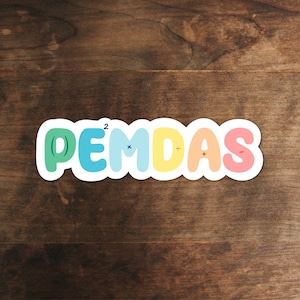 May include: A colorful sticker with the word "PEMDAS" written in rainbow colors. Each letter has a different color and a math symbol above it. The letters are P, E, M, D, A, and S. The symbols are parentheses, exponent, multiplication, division, addition, and subtraction.