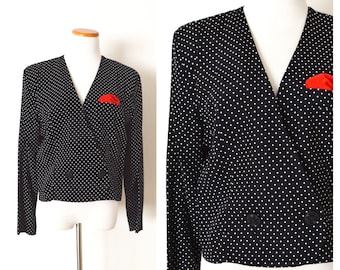 May include: A black and white polka dot blazer with a red pocket square. The blazer has a double breasted closure and long sleeves.