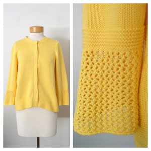May include: A yellow cardigan with a button-up front and crocheted bell sleeves.