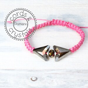 May include: A pink braided bracelet with two silver triangle-shaped beads and a smaller dark brown bead in the center.