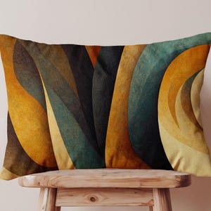 May include: Rectangular cushion with an abstract design. The cushion features a pattern of overlapping, curved shapes in shades of gold, teal, brown, and black. The cushion is resting on a small, wooden stool.