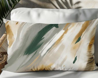 May include: Rectangular decorative pillow with an abstract design. The pillow features brushstrokes in shades of white, green, and gold. The pillow is resting on a white surface.