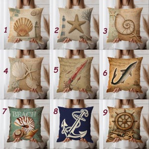Peut inclure: Coussin décoratif avec un motif de coquillage et de phare sur fond beige. Le coussin a une esthétique de carte postale vintage, avec un grand coquillage et un petit phare.