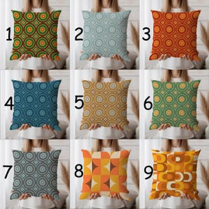 May include: Nine decorative throw pillows with retro geometric patterns. The pillows feature various color schemes, including green, orange, blue, and gold. Each pillow has a unique design, with circles, squares, and other shapes.