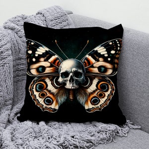 May include: Black throw pillow with a skull and butterfly design. The butterfly has brown, orange, and white wings with blue eyes. The skull is white with black eye sockets.