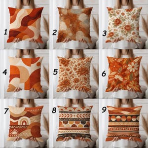 Op de afbeelding: Negen decoratieve sierkussens met verschillende ontwerpen worden getoond. De kussens hebben warme kleuren zoals oranje, bruin en beige. Ontwerpen omvatten abstracte vormen, bloempatronen en geometrische motieven. De kussens zijn vierkant en lijken van stof te zijn.