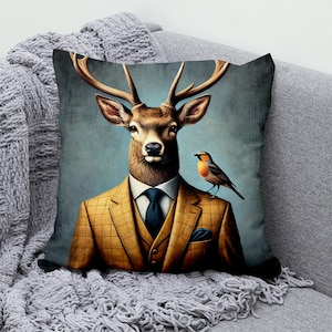May include: A throw pillow with a colorful illustration of a deer wearing a brown and yellow plaid suit and a blue tie. A small robin is perched on the deer's shoulder.