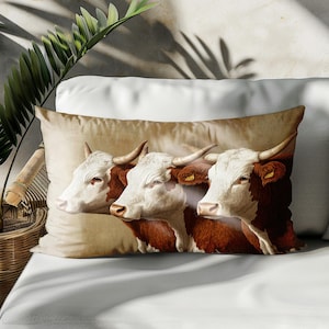 May include: A throw pillow with a brown and white cow print design. Three cows are shown in profile, with their heads turned to the side. The cows have brown and white markings, and their eyes are closed.