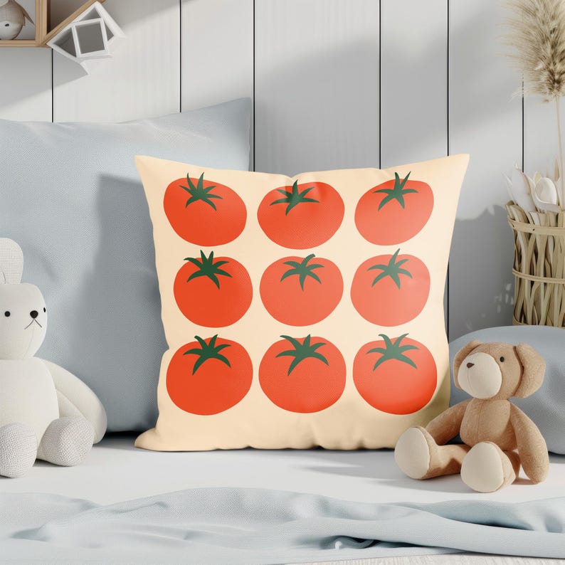 May include: A decorative pillow featuring a pattern of nine red tomatoes with green stems on a cream background. The pillow is square-shaped and adds a touch of whimsy to home decor.