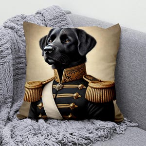 May include: A black Labrador Retriever wearing a gold and black military uniform with gold trim. The dog is looking to the left of the image. The background is a light brown color.