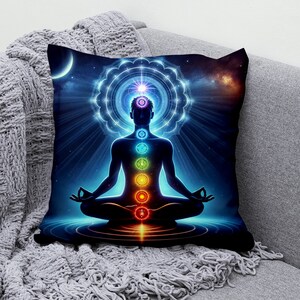 May include: A throw pillow with a colorful illustration of a person meditating with seven chakras, surrounded by a glowing mandala and a starry night sky.