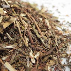 May include: A close-up of a pile of dried herbs, including stems and leaves, with a light brown colour.