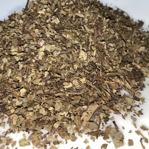 May include: A pile of dried, brown, and purple herbs. The herbs are loose and have a rough texture.