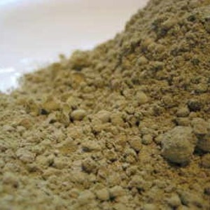 May include: Close-up of a pile of light green powder. The powder is made up of small, irregular particles.