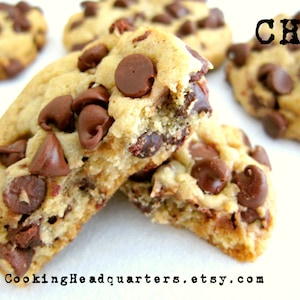 Puede incluir: Primer plano de galletas con chispas de chocolate rotas por la mitad, revelando su textura suave y masticable y las chispas de chocolate. Las galletas son de color marrón claro y tienen un ligero tono dorado. El texto "CHQ" es visible en la esquina superior derecha de la imagen.