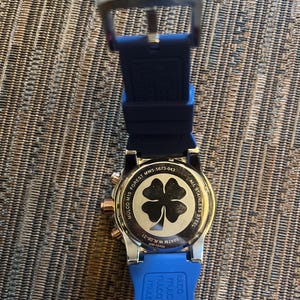 Pu&ograve; includere: Un orologio Mulco in acciaio inossidabile con cinturino in silicone blu. Il quadrante dell'orologio presenta un design a quadrifoglio. L'orologio ha dettagli in oro rosa ed &egrave; visibile il testo "MULCO M10 FOREST MW5-5673-043".