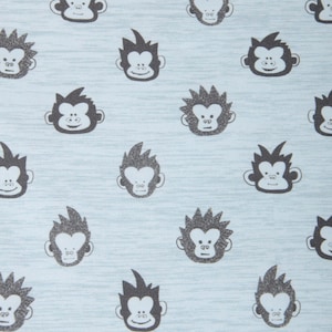 Könnte beinhalten: Ein hellblauer Stoff mit einem sich wiederholenden Muster aus schwarzen Affengesichtern. Die Affen haben verschiedene Frisuren und Gesichtsausdrücke.