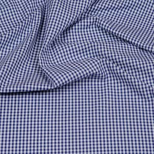 Könnte beinhalten: Ein blauer und weißer Gingham-Stoff mit einem strukturierten, gewebten Muster. Der Stoff ist gefaltet und drapiert, wodurch die Textur und das Muster sichtbar werden.