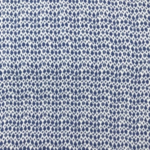 Könnte beinhalten: Nahaufnahme eines Stoffes mit einem sich wiederholenden Muster aus marineblauen Rauten auf weißem Hintergrund. Die Rauten haben ein verwittertes, strukturiertes Aussehen und erzeugen einen visuellen Kontrast.