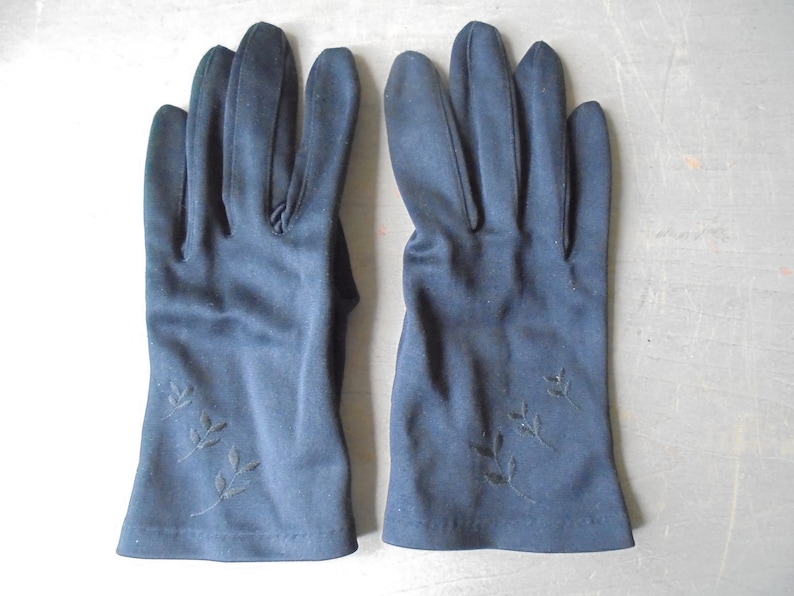 Peut inclure: Une paire de gants noirs avec des motifs de feuilles brod&eacute;s sur les poignets.