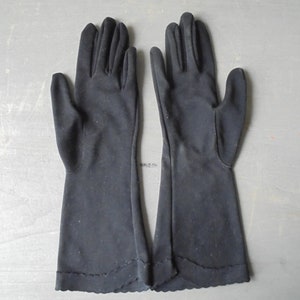 Peut inclure: Une paire de longs gants noirs avec un bord festonn&eacute;.