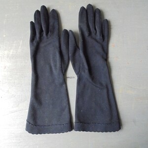 Peut inclure: Une paire de longs gants noirs avec un bord festonn&eacute;.