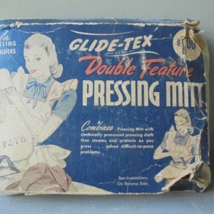 May include: Vintage box for a Glide-Tex Double Feature Pressing Mitt. The box is blue with white and red text. The text on the box reads "Combines Pressing Mitt with chemically processed pressing cloth that steams and protects as you press... solves difficult-to-press problems."