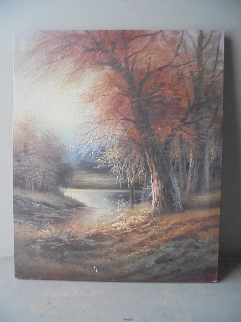 May include: A painting of a forest scene with a lake in the foreground. The trees are mostly brown and orange, with some green leaves. The lake is a light blue color, and the sky is a light gray. The painting is done in a realistic style.