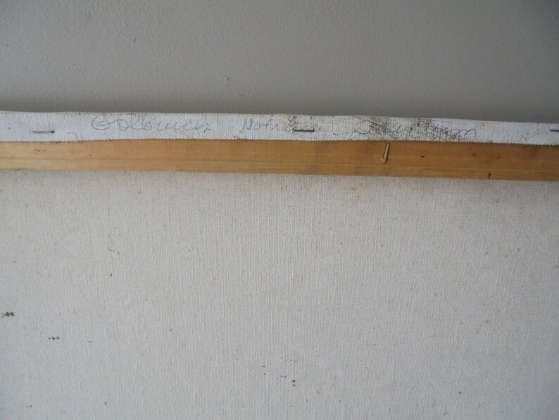 May include: Close-up of the back of a canvas painting with a wooden frame. The artist's signature is visible on the canvas: "Goldie" and "Norine".