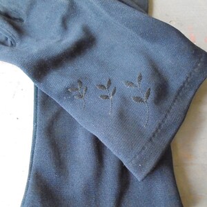 Peut inclure: Une paire de longs gants noirs avec un d&eacute;licat motif de feuilles brod&eacute;es sur le poignet.