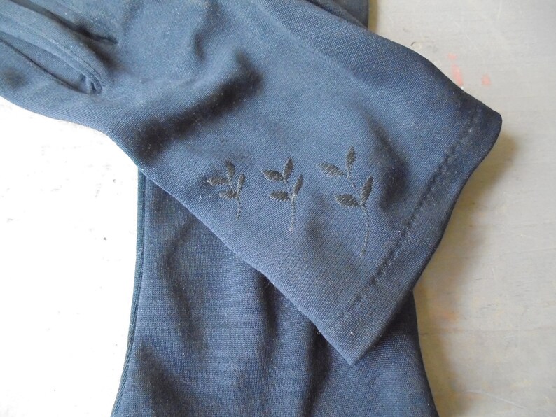 Peut inclure: Une paire de longs gants noirs avec un d&eacute;licat motif de feuilles brod&eacute;es sur le poignet.