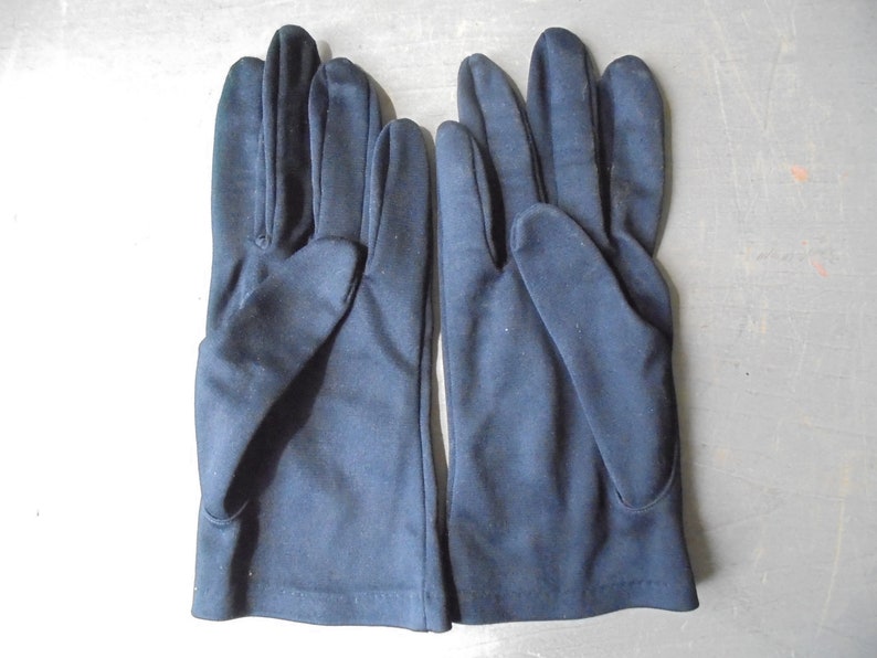 Peut inclure: Une paire de gants bleu fonc&eacute; en tissu lisse.