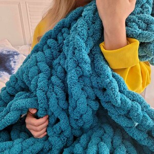 Pu&ograve; includere: Una coperta in maglia grossa color turchese con una texture morbida e soffice. La coperta &egrave; realizzata con filato spesso e ha una trama larga e aperta.